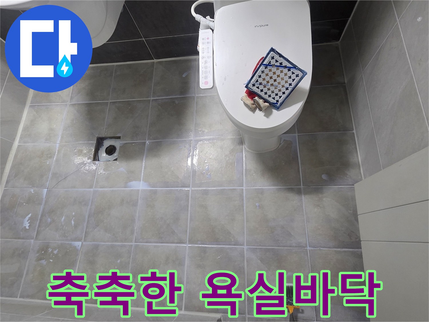 물기가 머물러 있는 욕실 타일 표면 사진입니다.