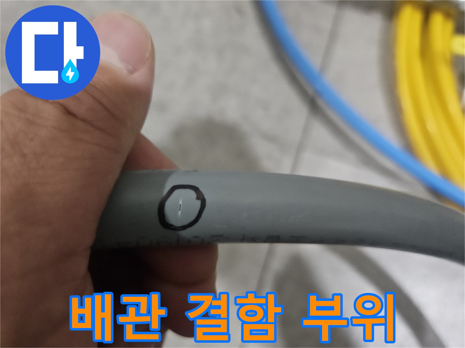 손에 들린 회색 배관의 검은색 표시 지점