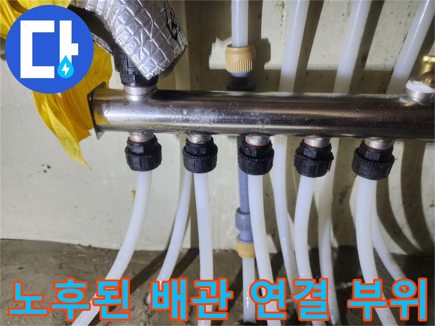 분배기 하단에 연결된 흰색 PEX 배관과 금속 분배기 상세 사진