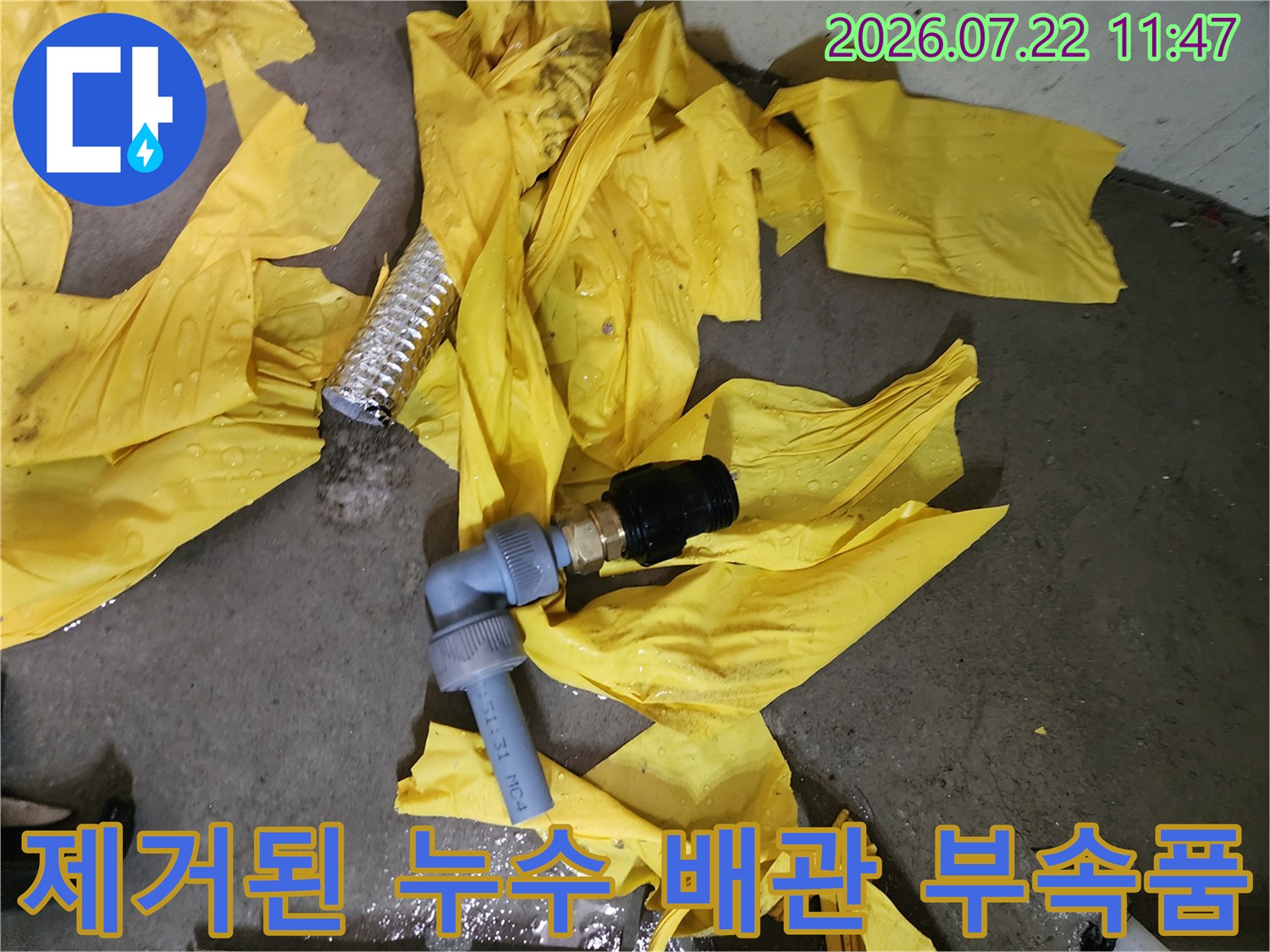 작업 현장에서 수거한 파손된 회색 플라스틱-배관 연결 부위와 보온재 일부