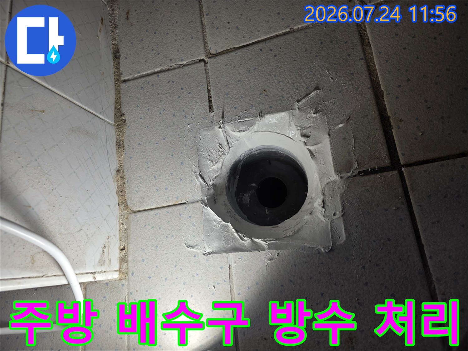 배수구 주변에 흰색 방수재를 도포한 현장 사진