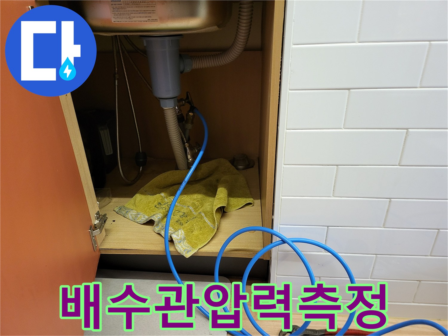 싱크대-하단-배수구-에-공압-장비를-연결한-모습