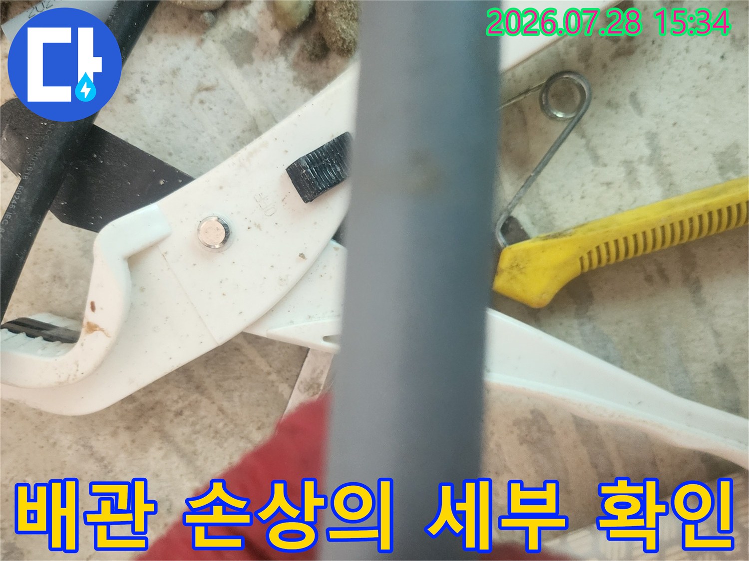 작업자가 파악 중인 회색 배관의 근접 샷