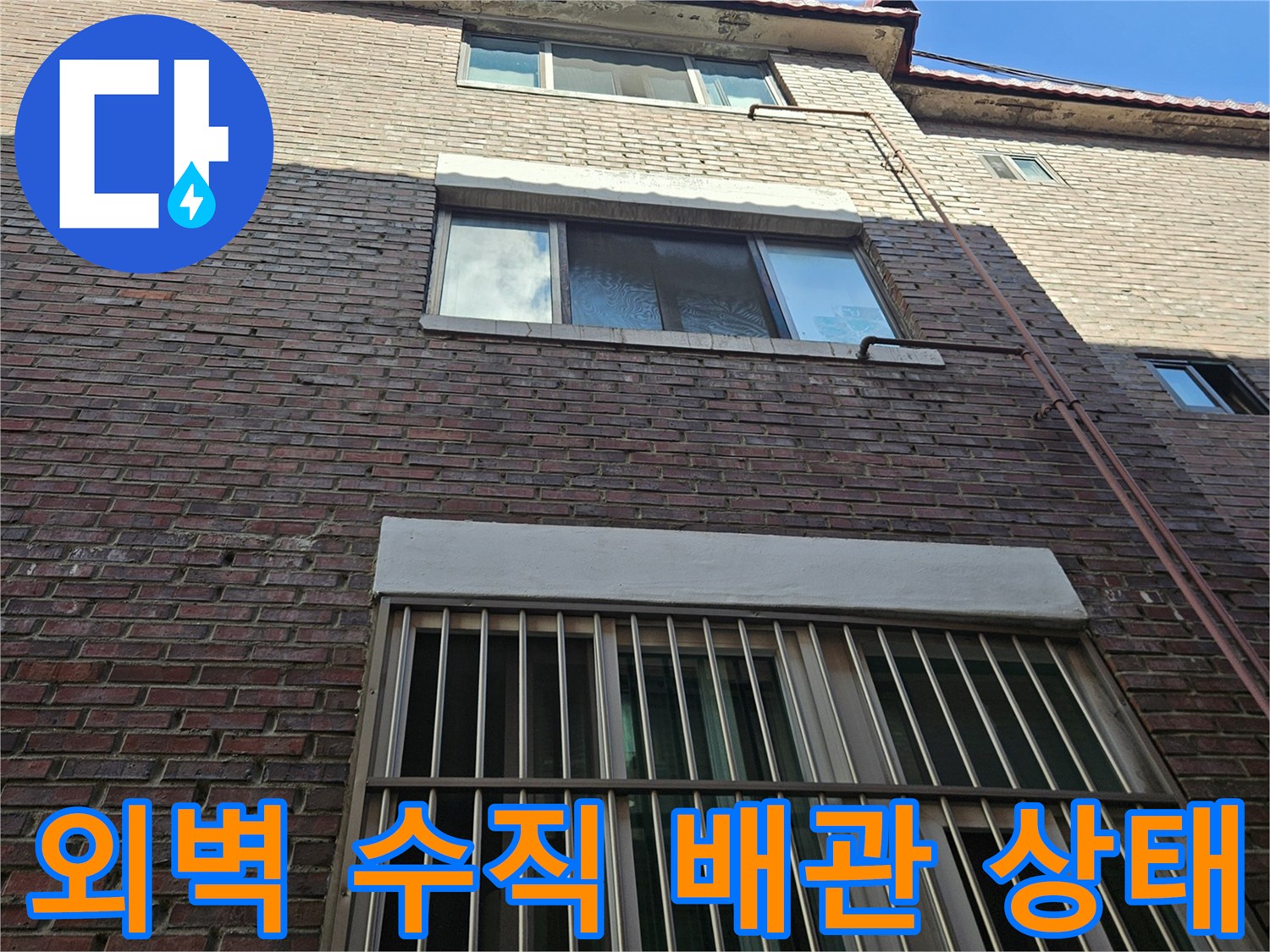 건물 외벽 타일과-창문 아래 배관 모습