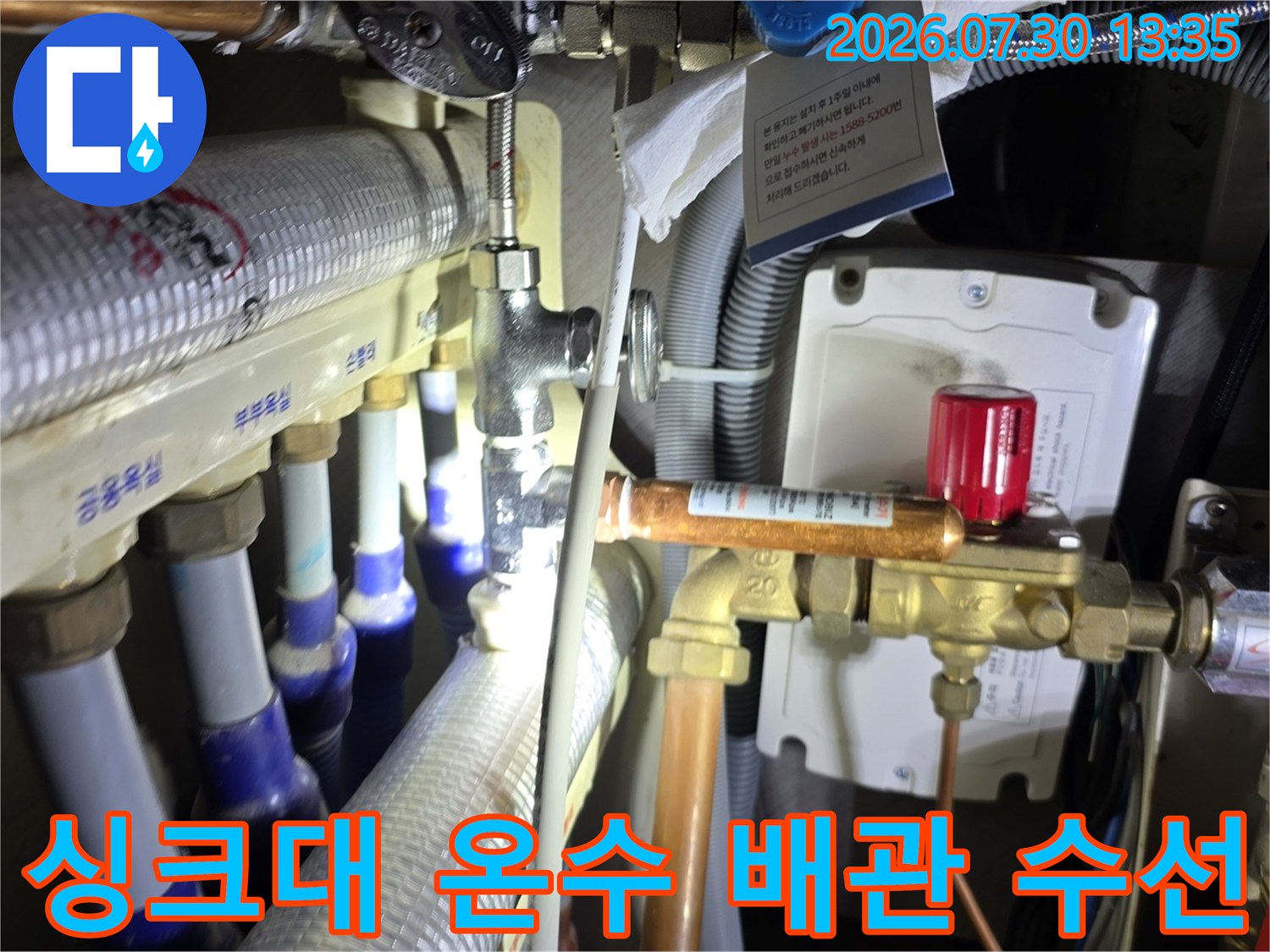 싱크대 아래 위치한 온수 분배기 배관의 연결 부위 보수 작업 현장