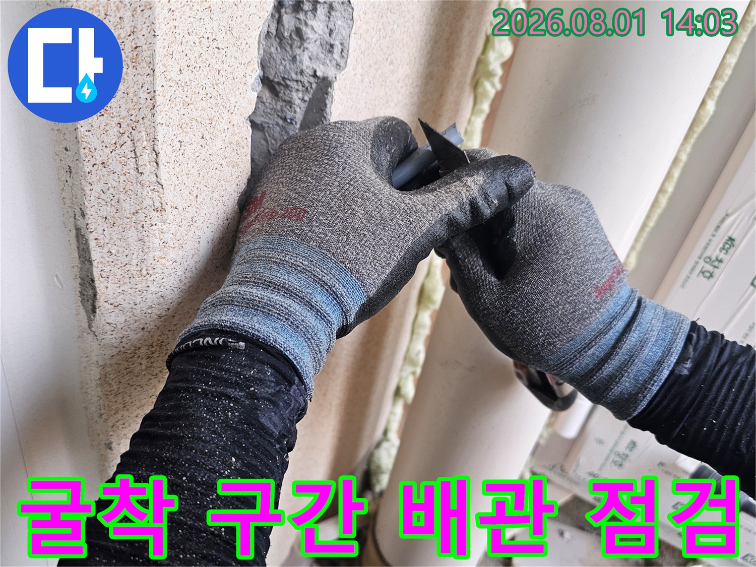 작업자가 장갑을 끼고 타일 파쇄 부위의 누수 지점을 직접 확인하는 모습