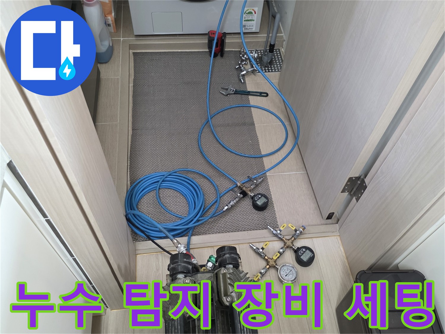 화장실 바닥에 놓인 공압 테스트용 컴프레셔와 게이지