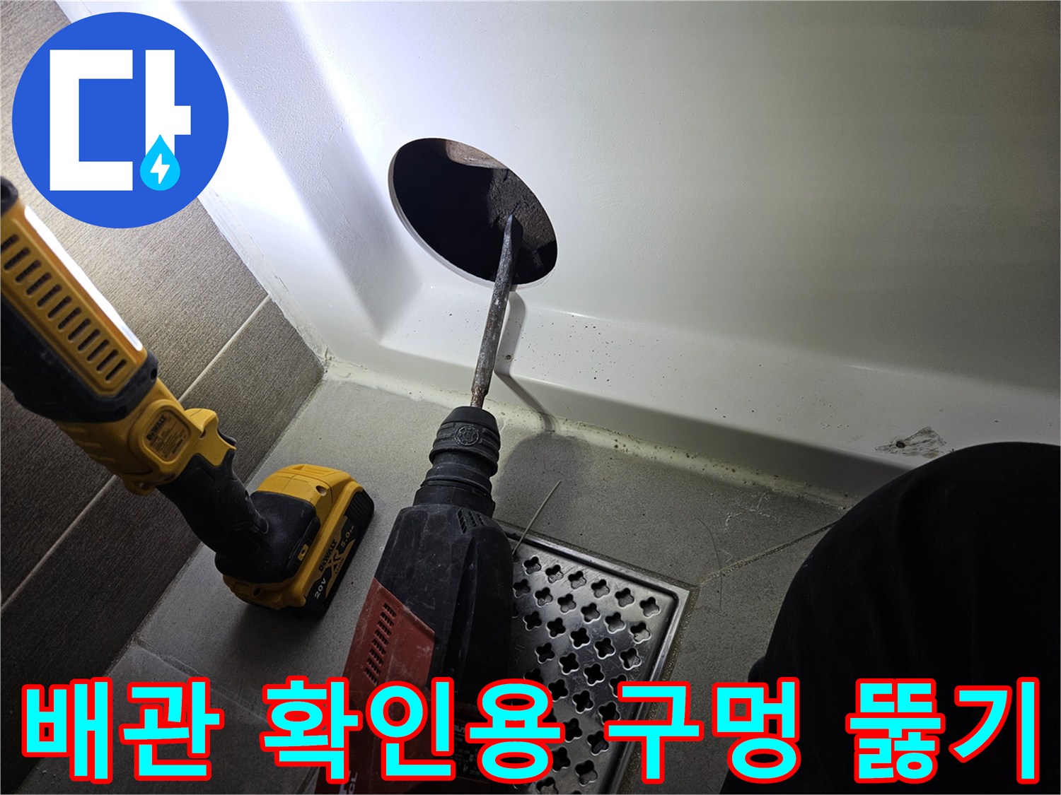 전동 드릴로 욕조 패널에 구멍을 내는 작업 현장