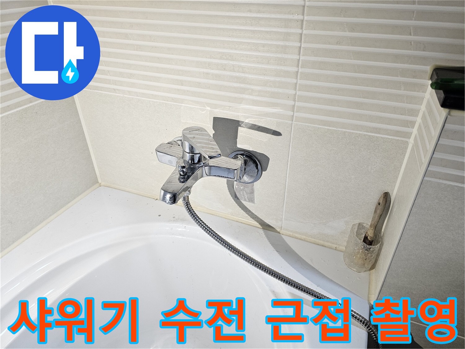 욕조 옆 벽면에 설치된 은색 샤워 수전