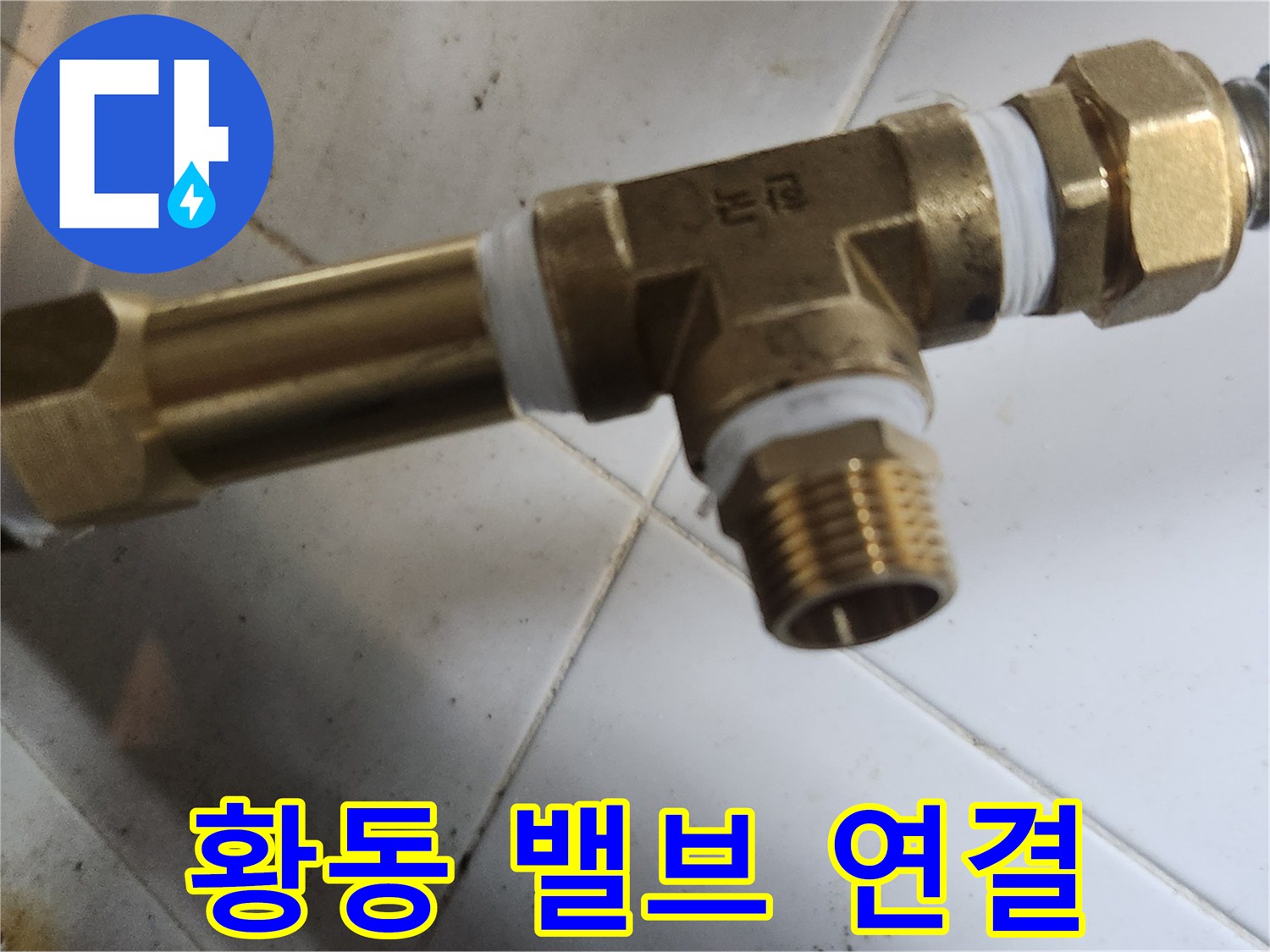 황동 재질의 T자형 분기 밸브와 파란색 배관