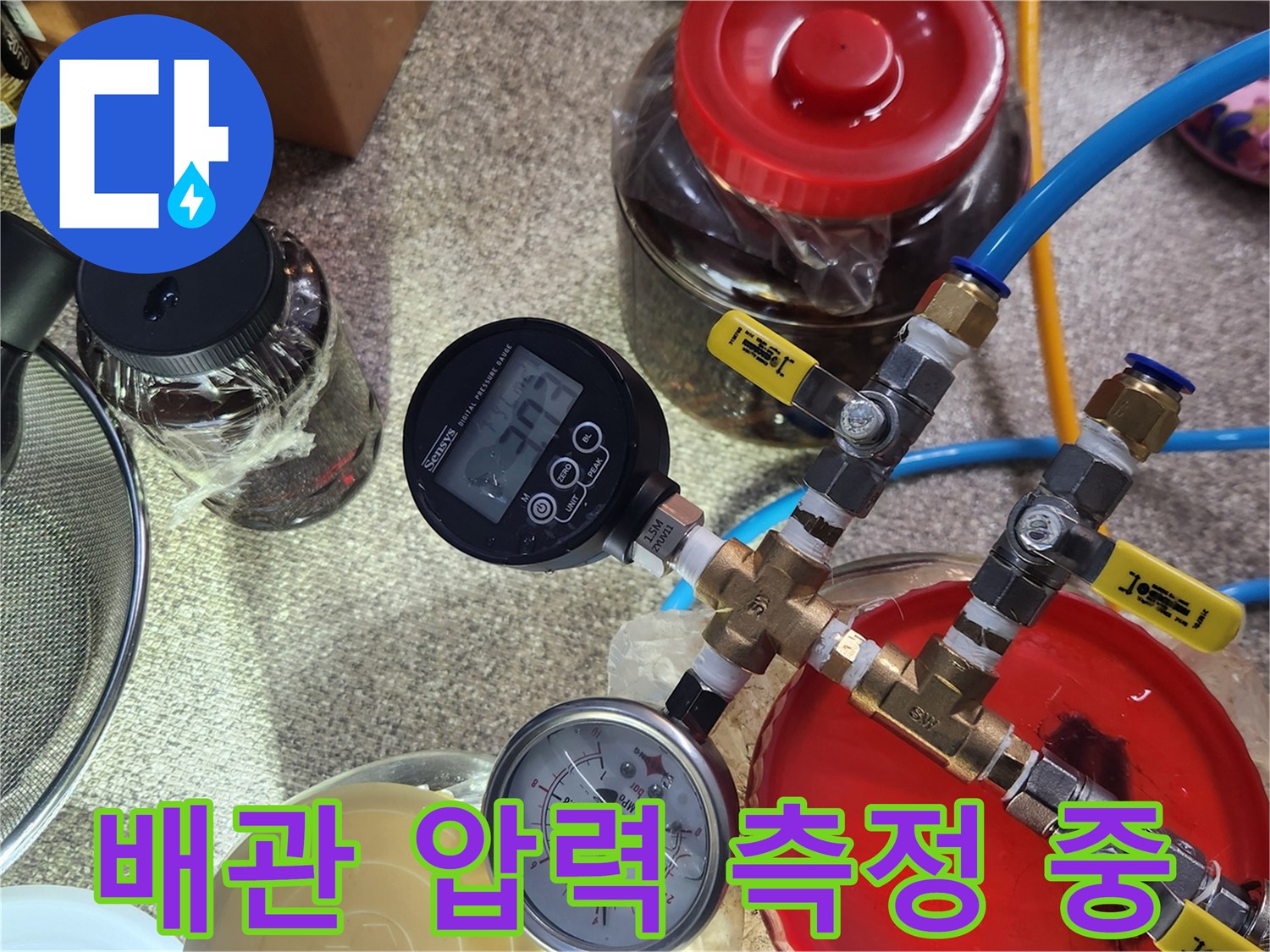 파란색 호스와 연결된-디지털 압력계의 수치 확인