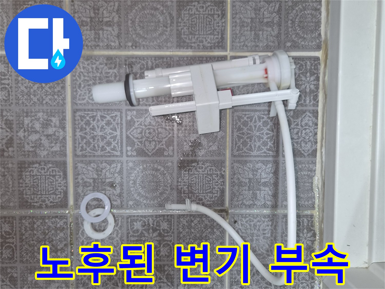 타일 위에 놓인 분리된 변기 필밸브와 연결관
