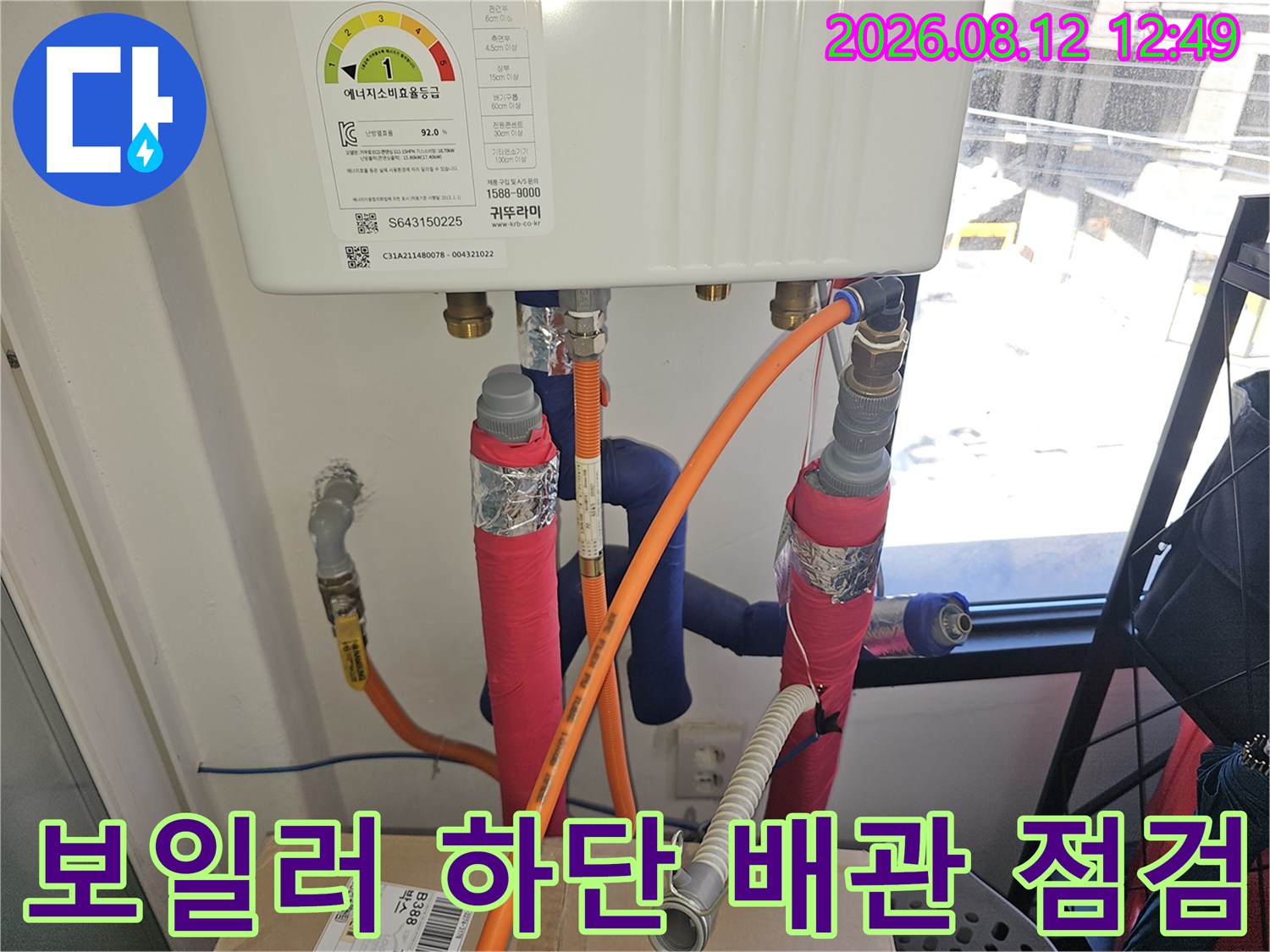 보일러 아래쪽의 다양한 연결 배관 및 호스 모습