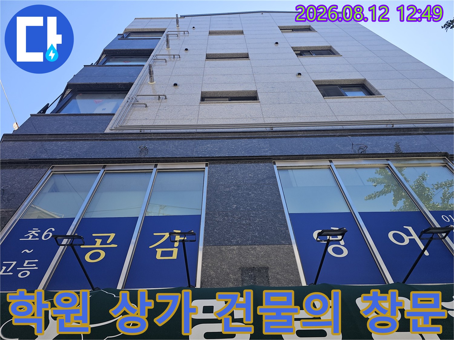 파란색 글씨가 적힌 상가 건물의 외벽 전경입니다.