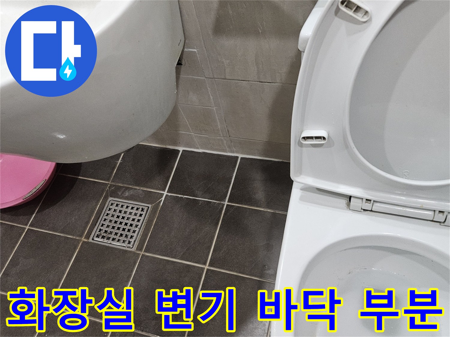 화장실-바닥의-어두운색-타일과-배수구-시설물