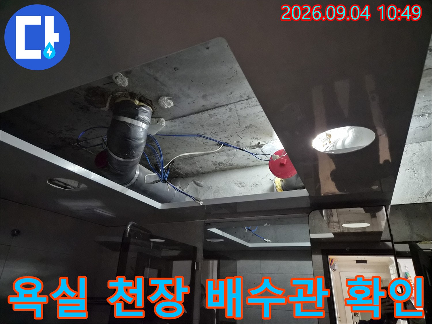 욕실 내부-천장재를 개방하여 노출된 배수 파이프와 주변 환경