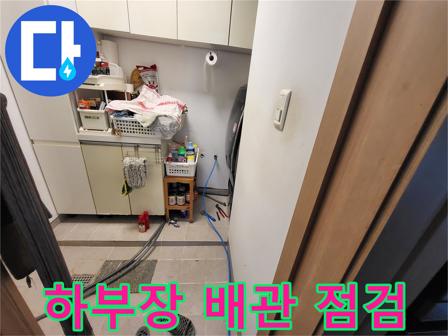 싱크대 하단 선반 아래쪽의 호스와 수도 연결 부위 근접 촬영