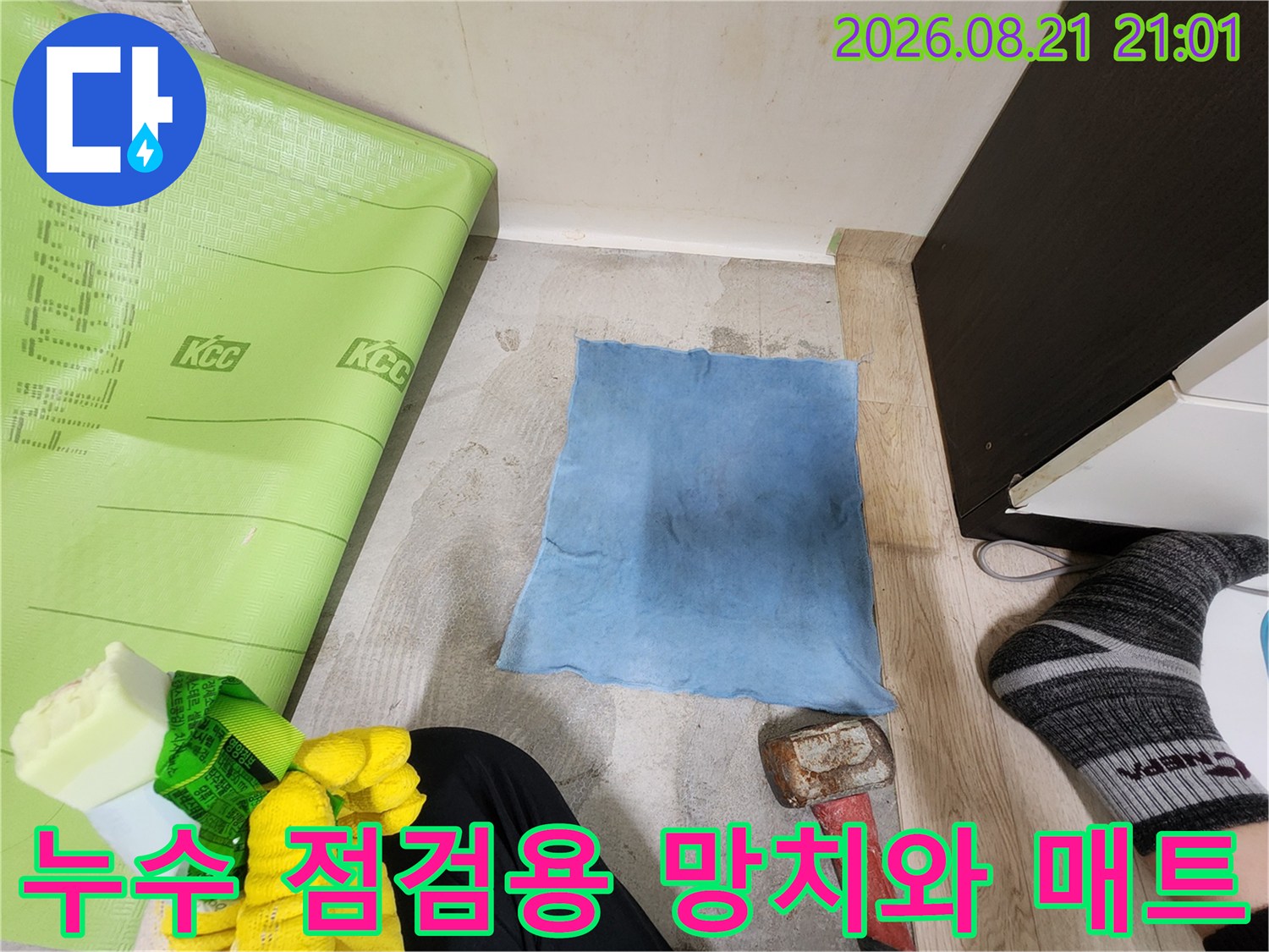 작업 현장 바닥에 놓인 망치와 파란색 천의 모습