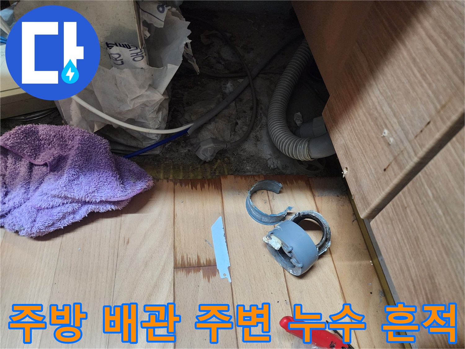 싱크대 아래쪽 배수 부속과 젖은 바닥재 상태
