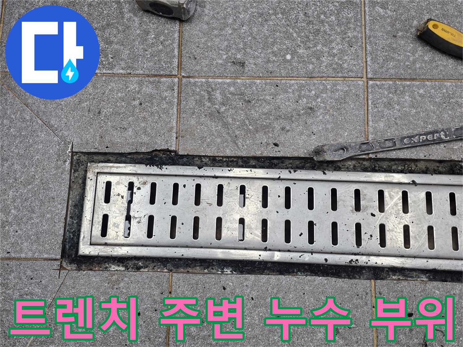 작업 도구와 함께 촬영된 배수 트렌치 및 타일 바닥