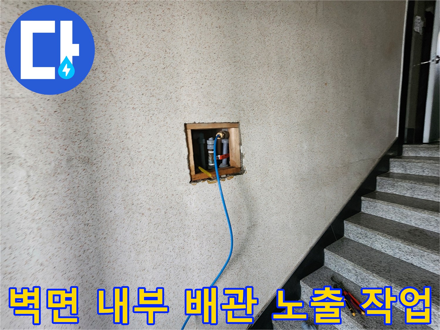 타공된 벽 안쪽의 배관과 파란색 탐지용 호스 연결