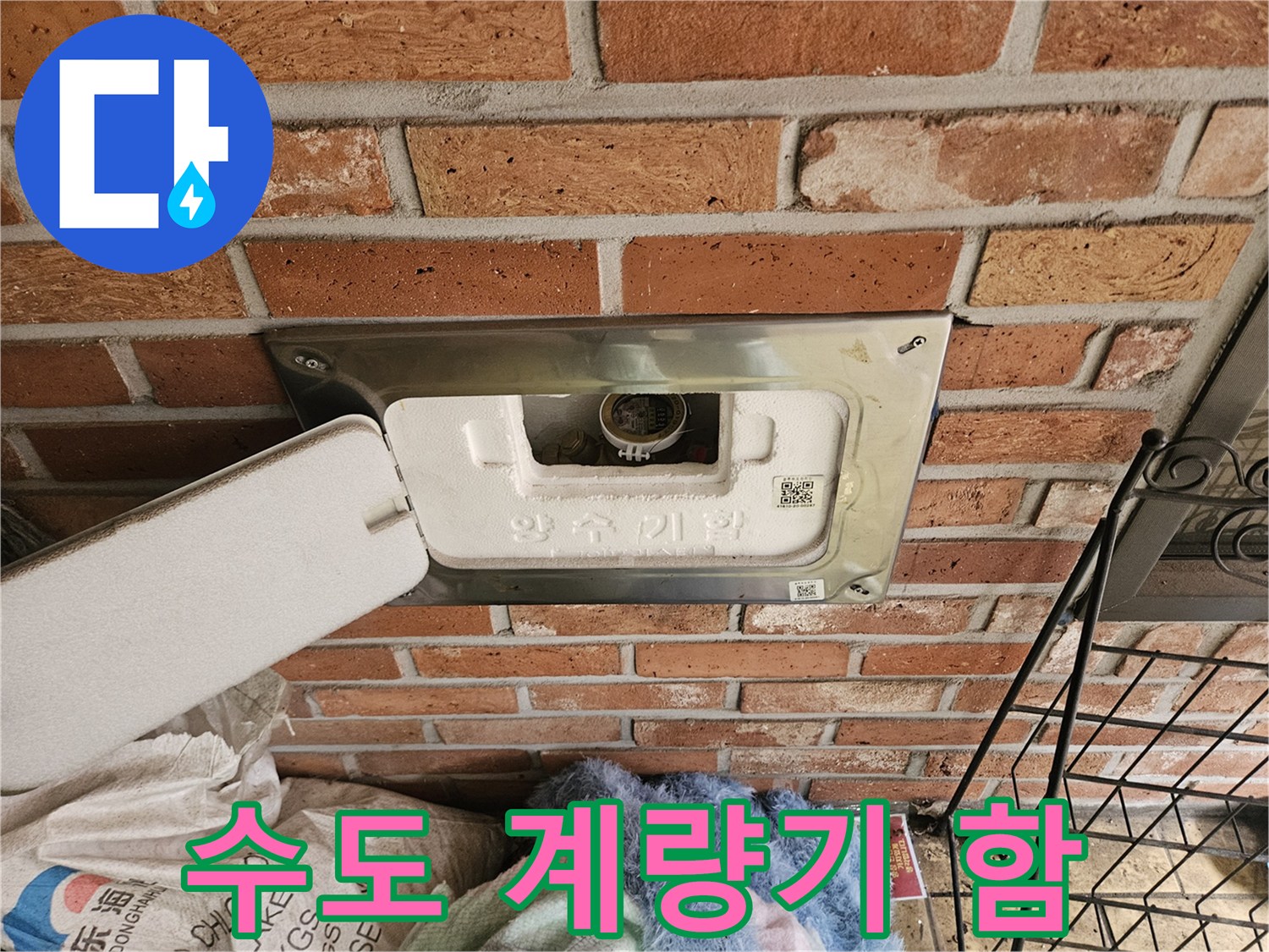 벽돌-계단-사이-수도-계량기-함-개방-사진