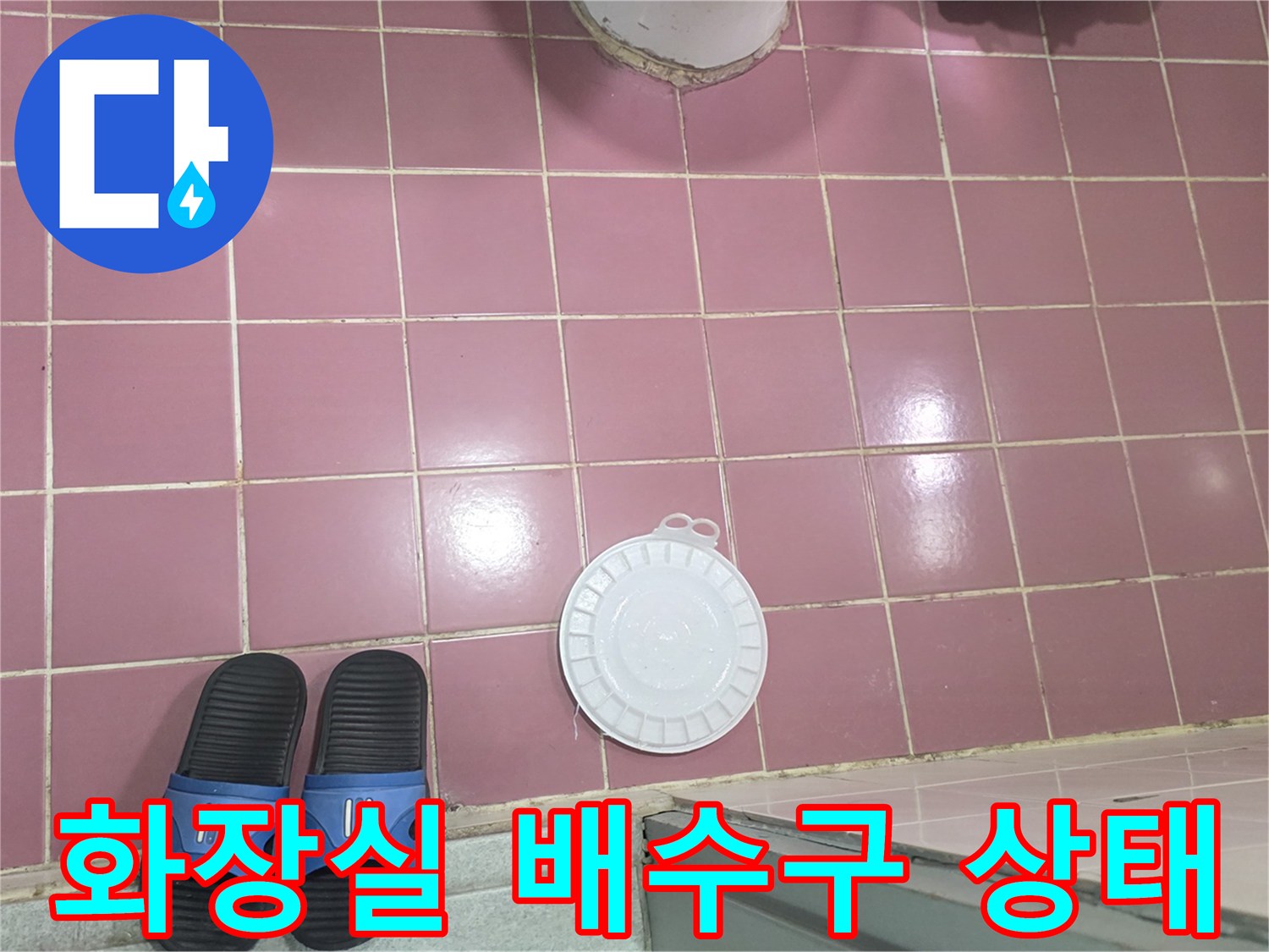 분홍색 타일 위 하얀 배수구 덮개