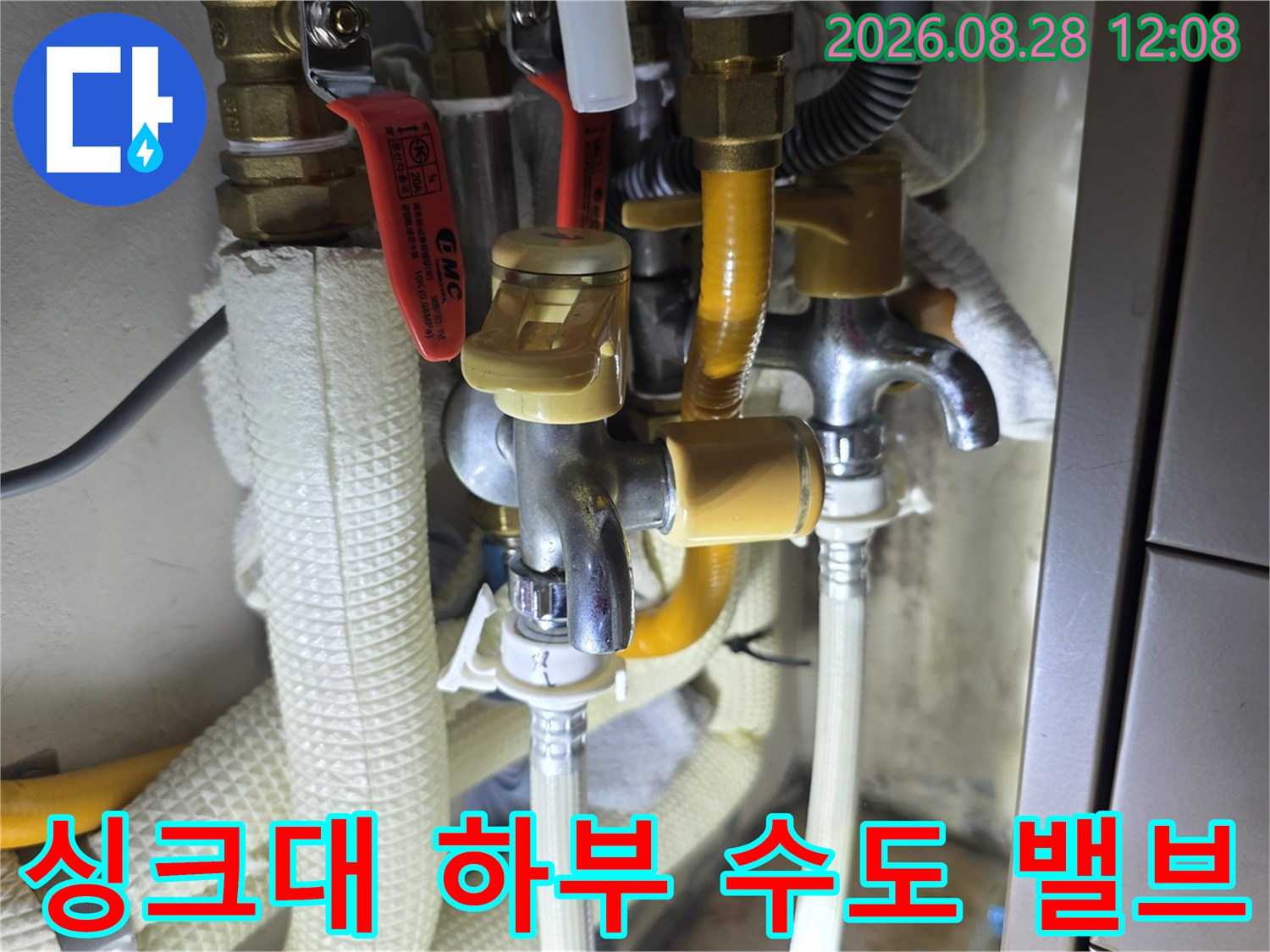 노란색 보온재가 입혀진 배관과 금속 소재의 수도 밸브 연결 부위입니다.