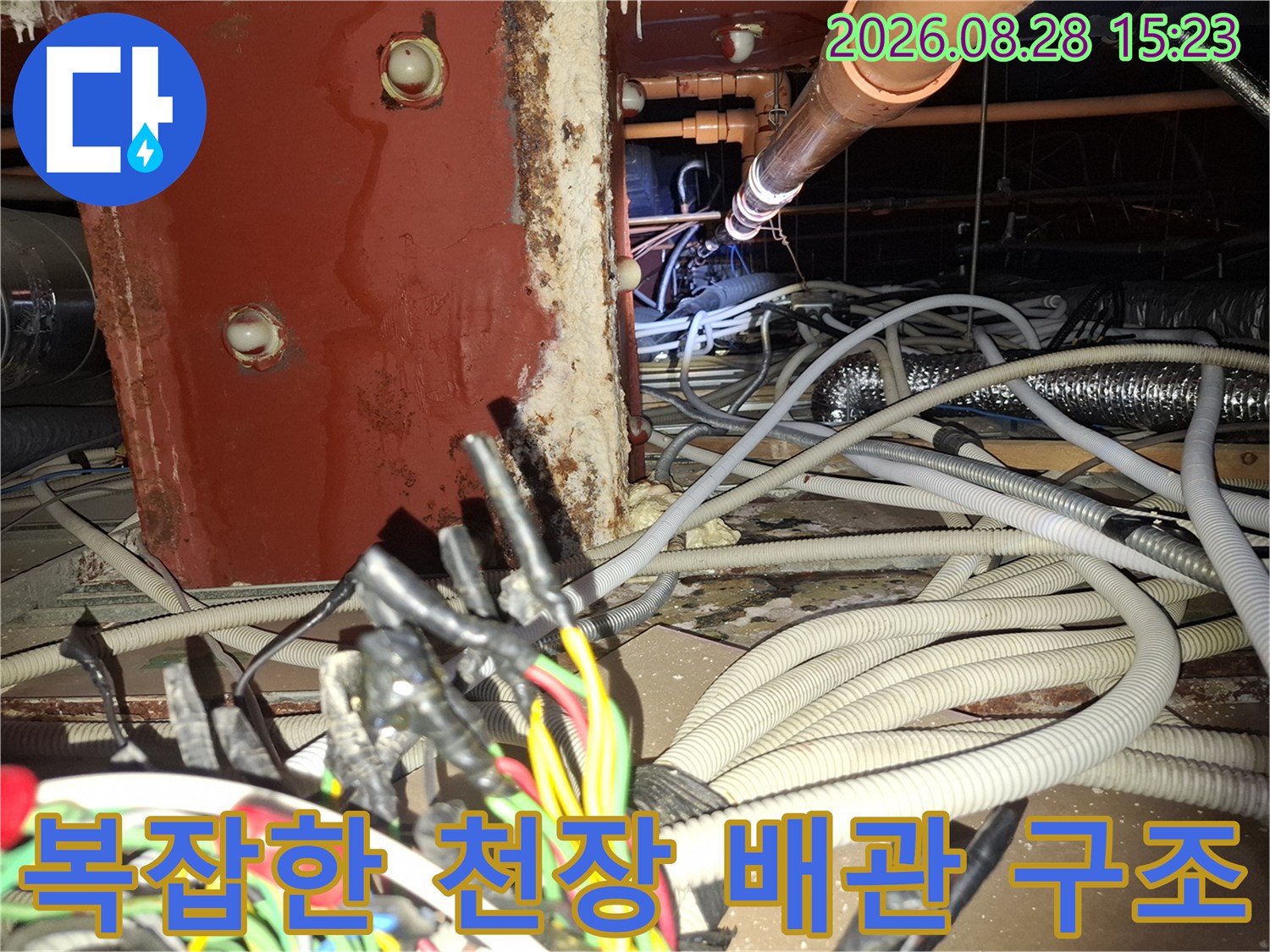 붉은 기둥 부근의 습기 맺힌 배관과 전선들