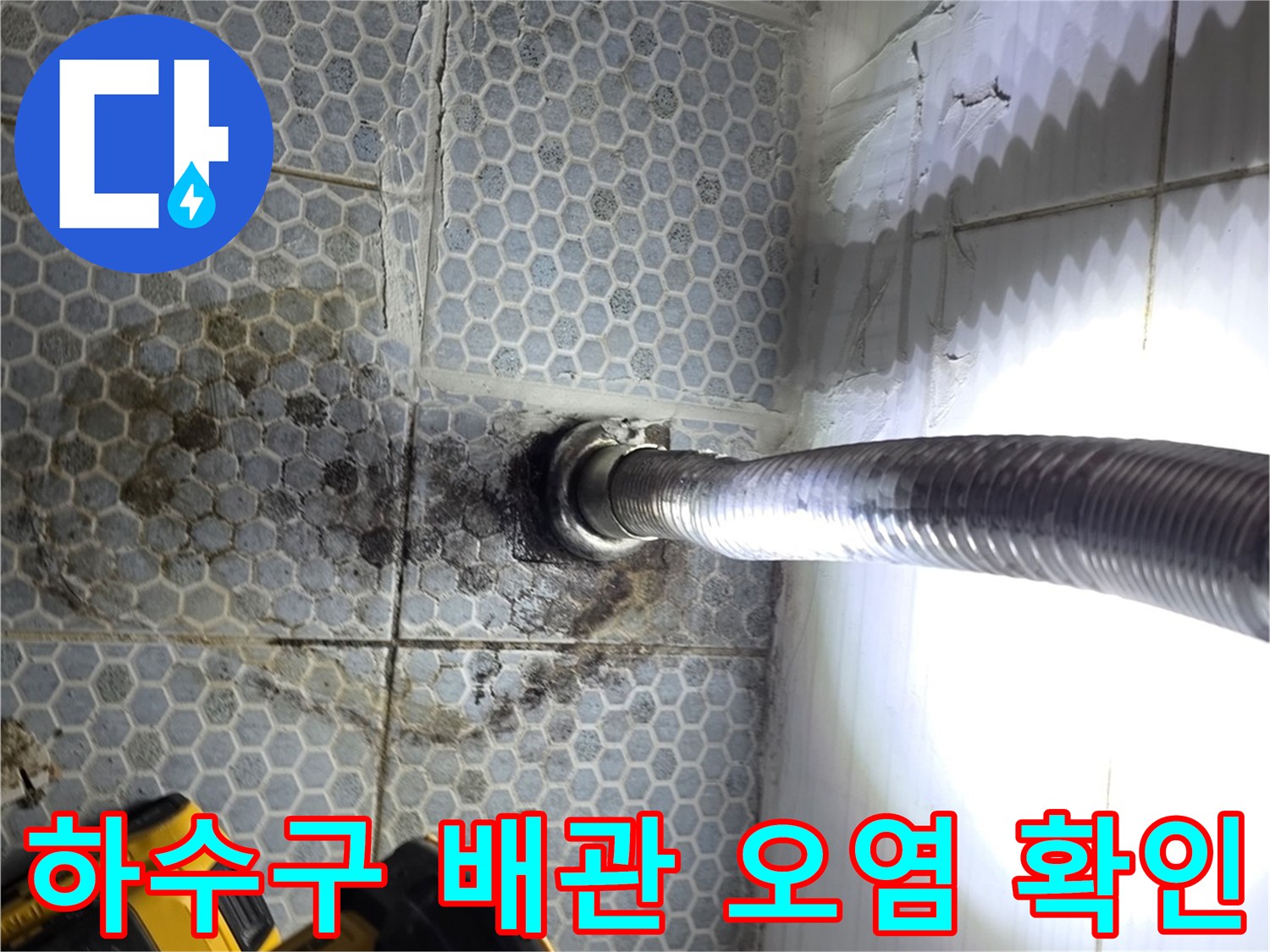 은색 주름 배관 주변의 젖은 타일 표면