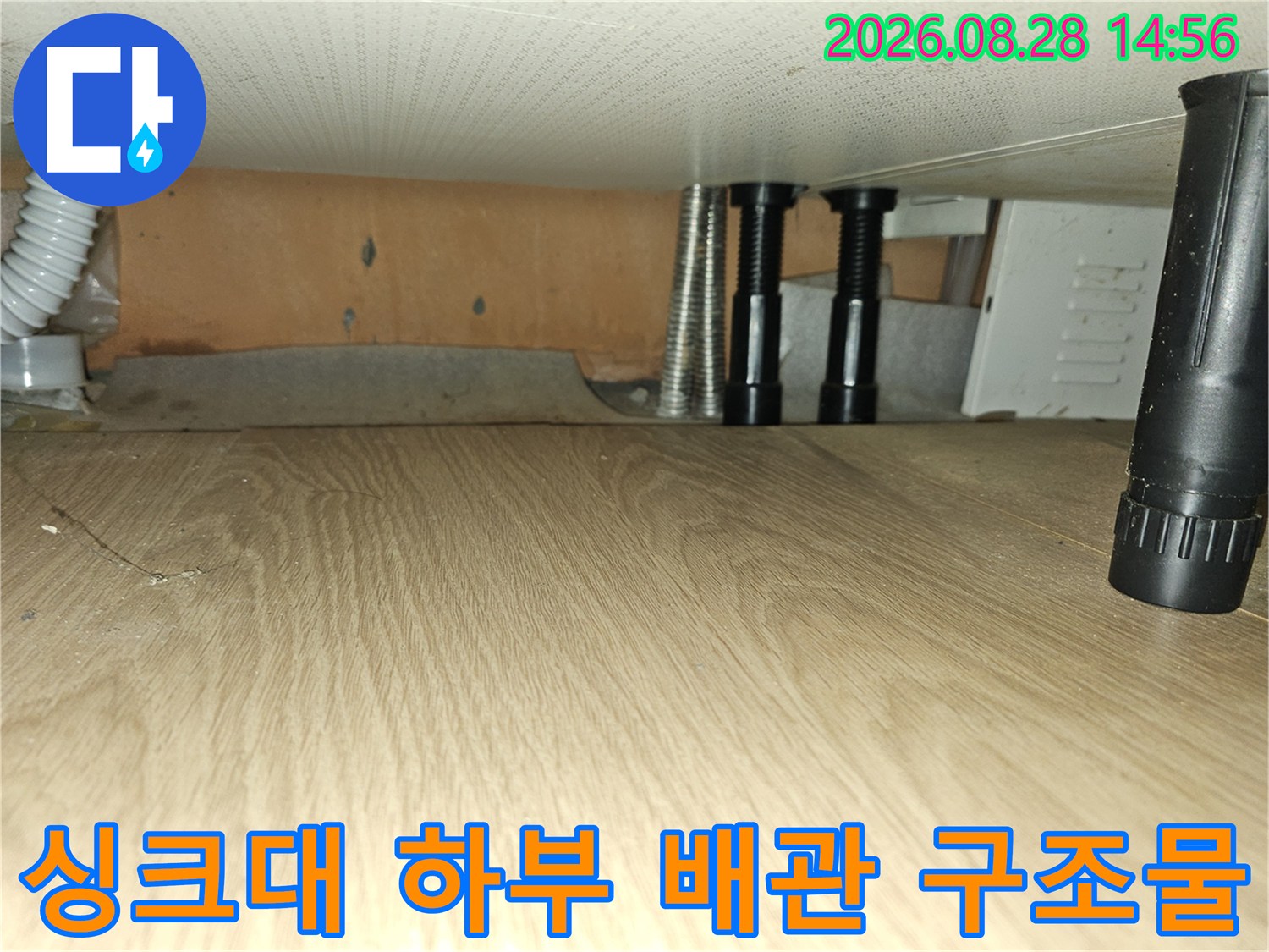 싱크대 아래쪽 흰색 주름관과 검은색 지지대 부위