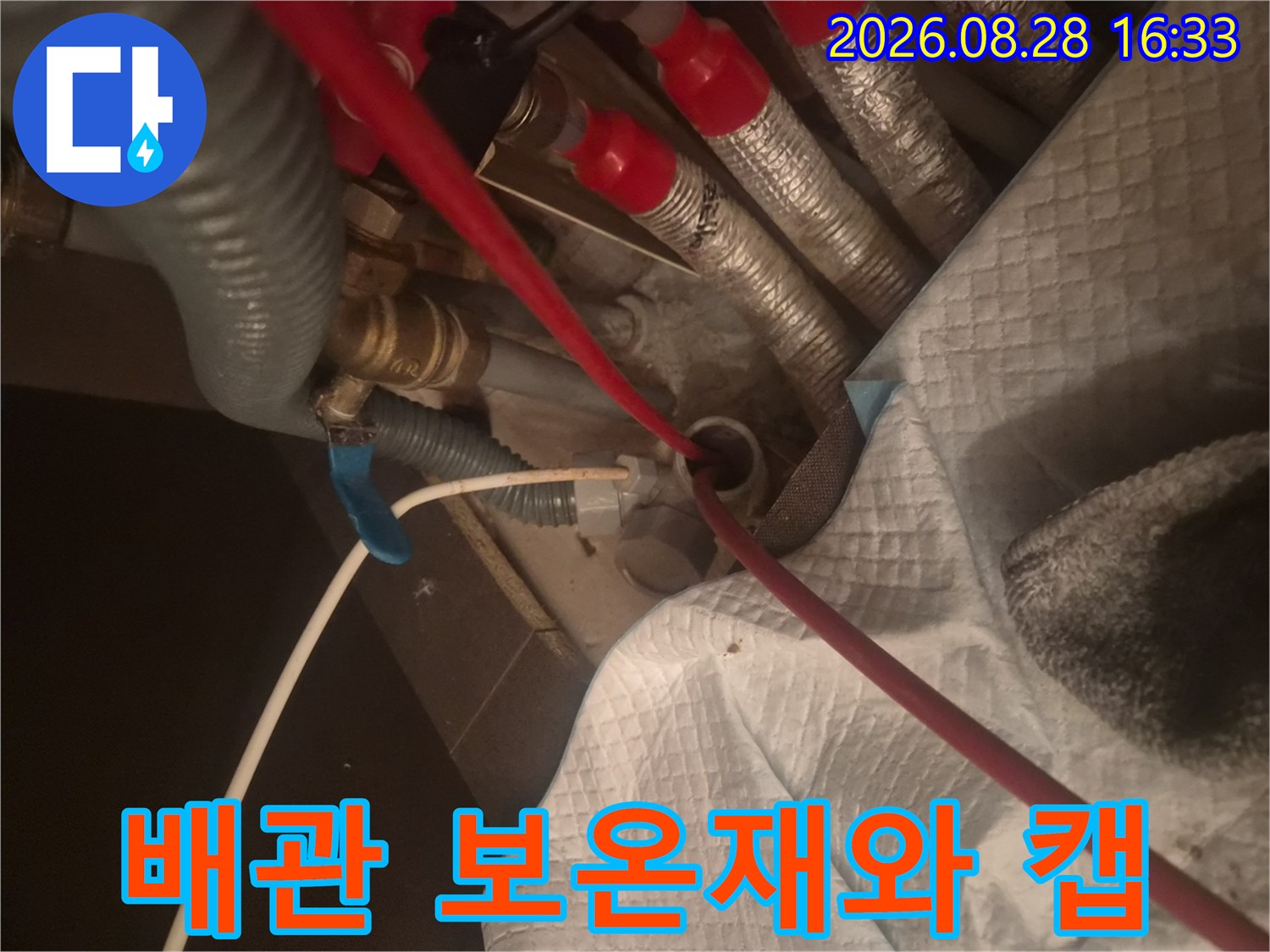 은색 보온재로 마감된 배관과 붉은색 연결 부위