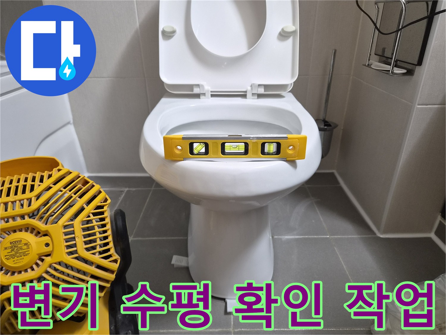 변기 위에 올려둔 노란색 수평계와 공구
