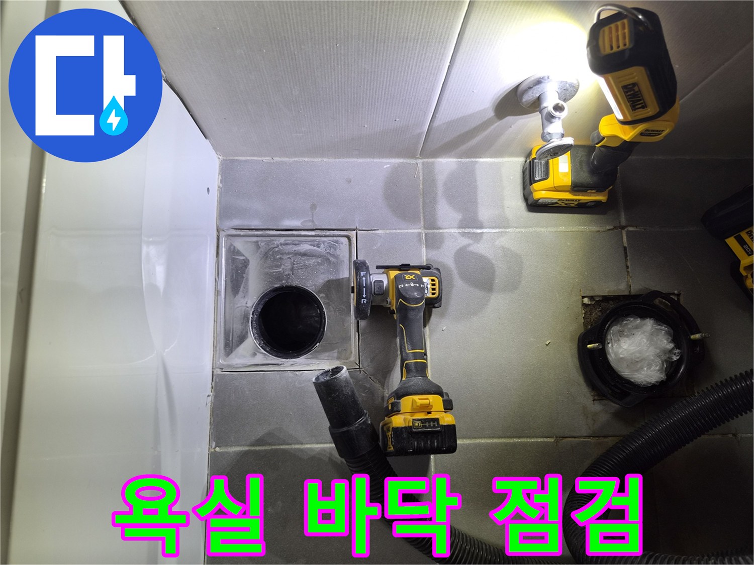 화장실 배수구와 작업용 전동 공구가 놓여 있는 현장입니다.