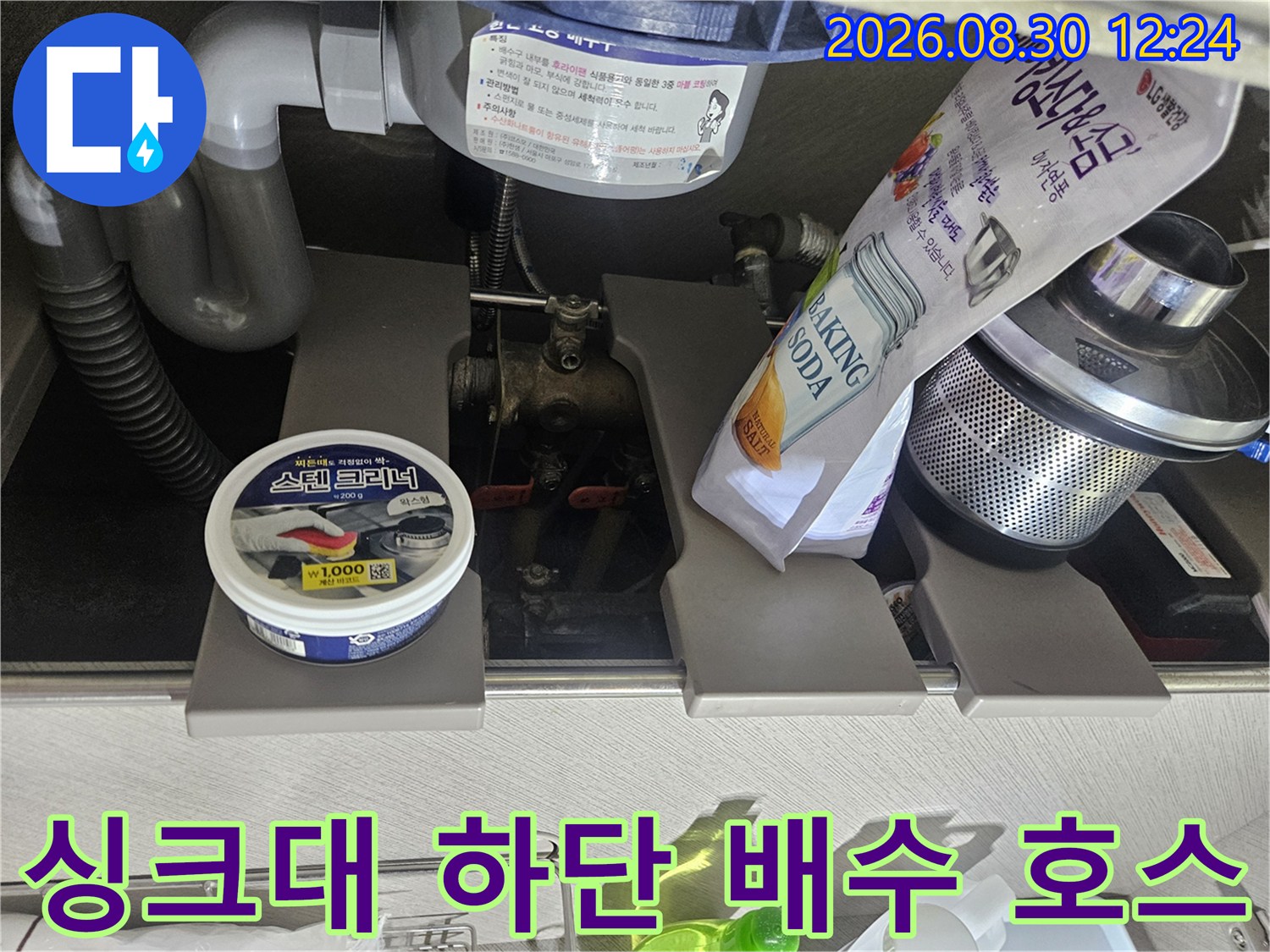 싱크대 아래쪽의 굽어진 배수 호스와 연결부 근접 사진