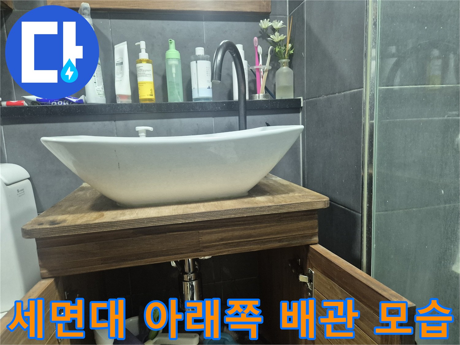 나무 선반 아래 위치한 세면대 하단 구조물