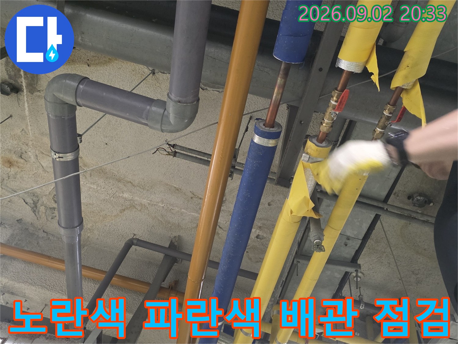 천장 설비-보온재가 씌워진 노란색과 파란색 배관의 근접 촬영