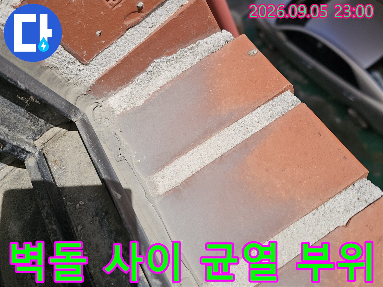 붉은 벽돌 마감재와 배관 하단부의 갈라진 틈새입니다.