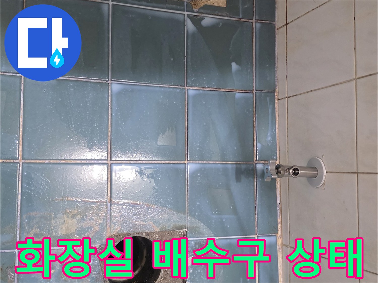 파란색 타일 바닥의 배수구와 배관 입구 모습
