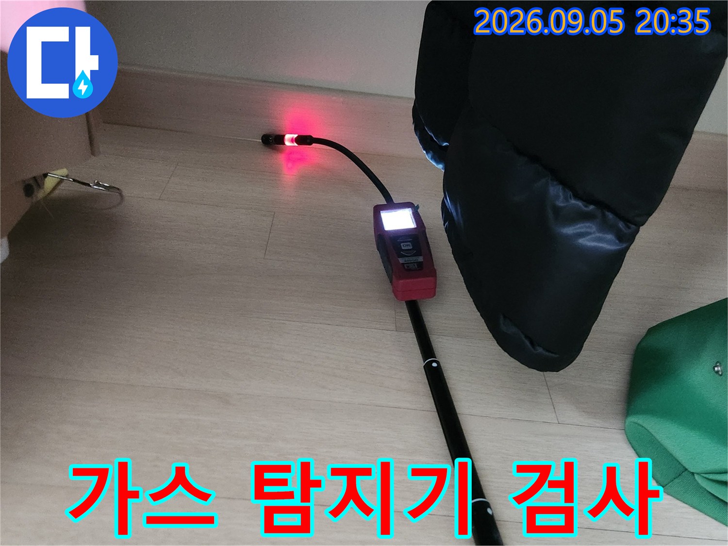 옷방 구석 바닥에서 가스 탐지기로 누수 지점을 확인하는 모습입니다.
