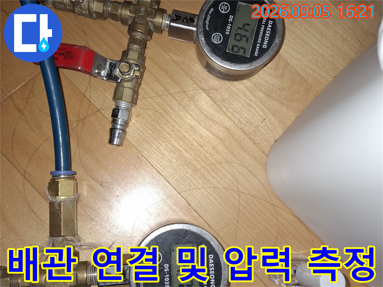 황동-연결부와-파란색-호스가-연결된-압력측정-장치