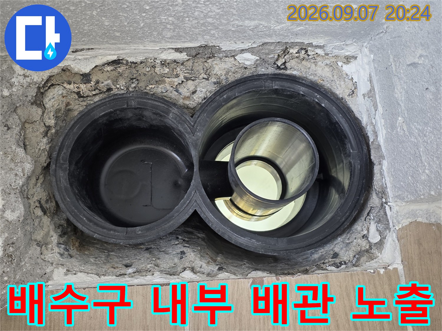 탈거된 타일 사이로 보이는 검은색 배수 배관 구조