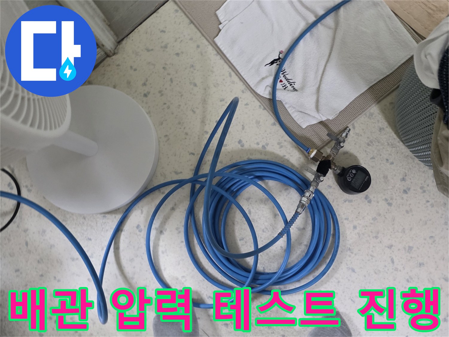 배관 연결 부위에 장착된 압력계와 파란색 호스