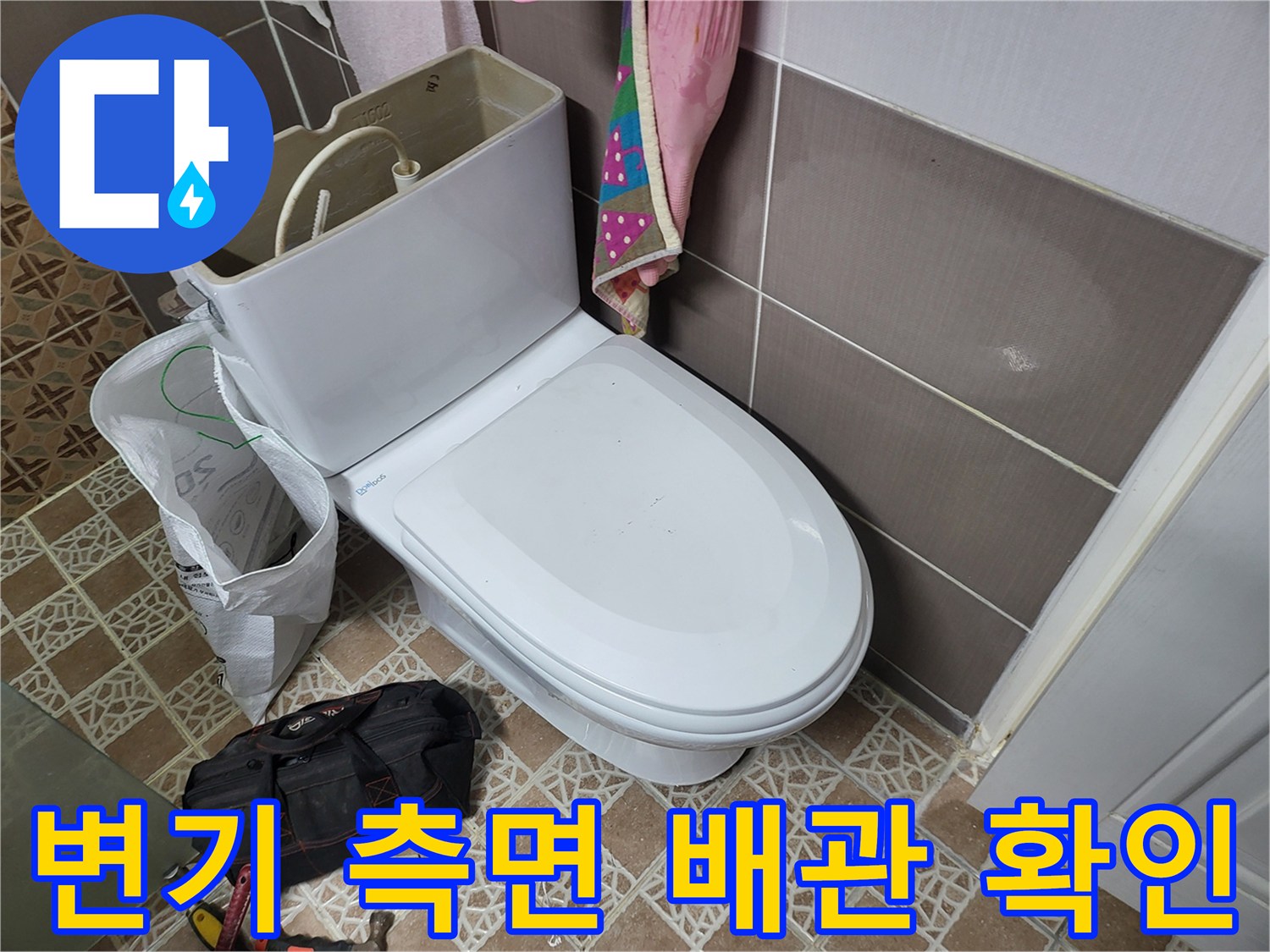 변기 옆 급수 밸브와 바닥 타일의 모습