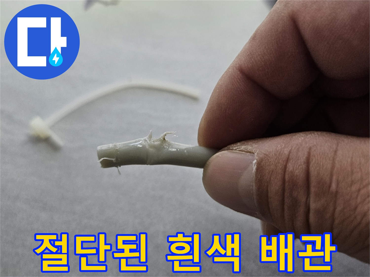 사용자가 손으로 잡고 있는 찢어진 배관 호스 부위
