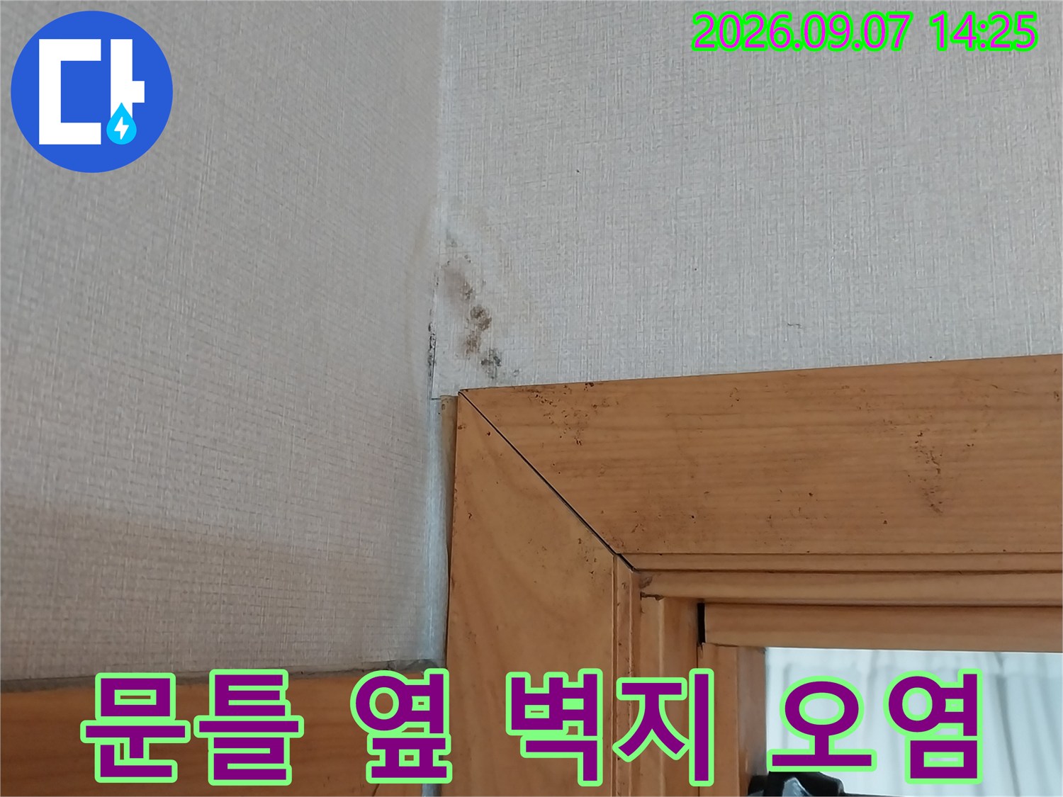 나무 문틀과 벽지가 만나는 곳의 젖은 흔적입니다.