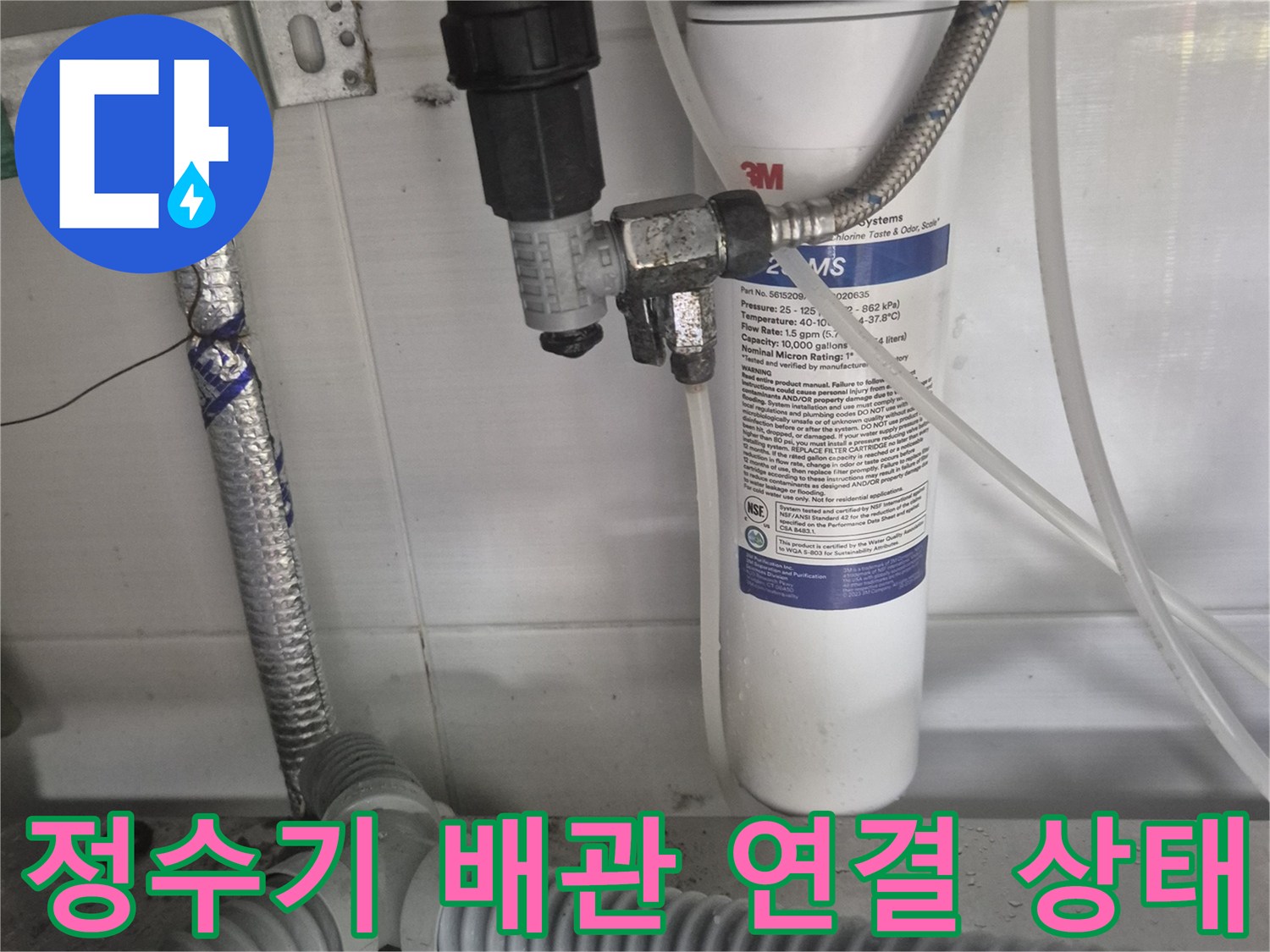 싱크대 하부장 내부의 정수기 필터와 앵글밸브 연결 부위 사진