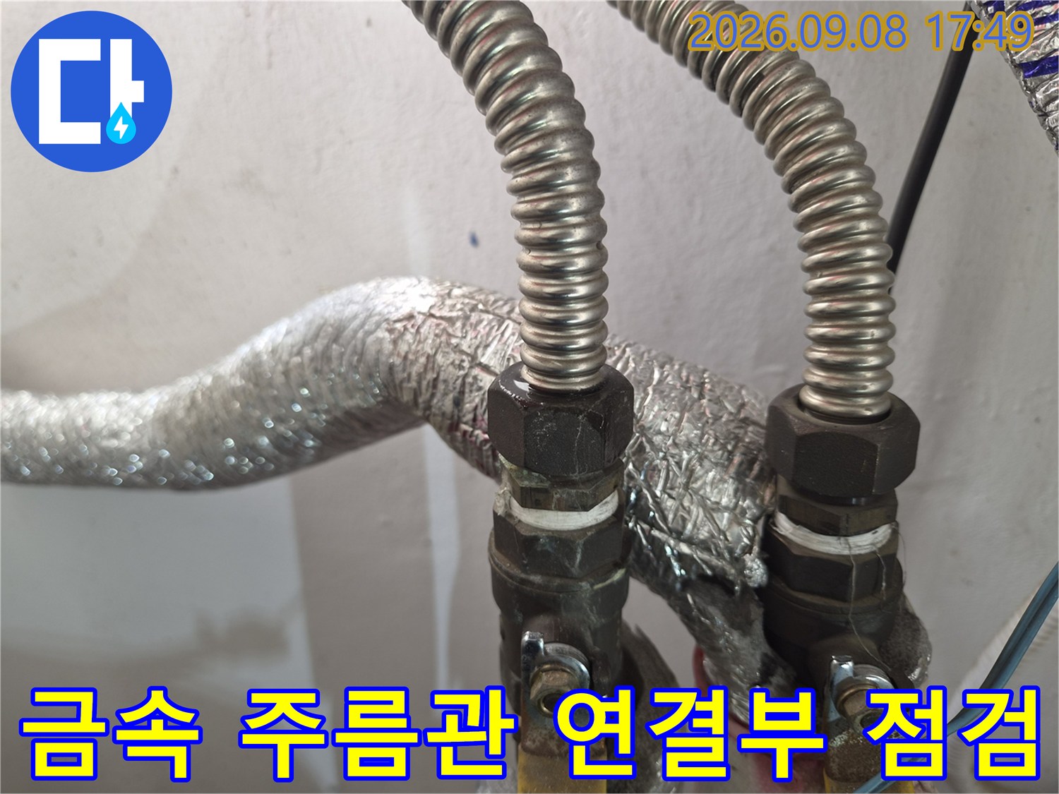 은박 보온재로 감싸진 배관과 금속제 연결 어댑터의 상세 모습