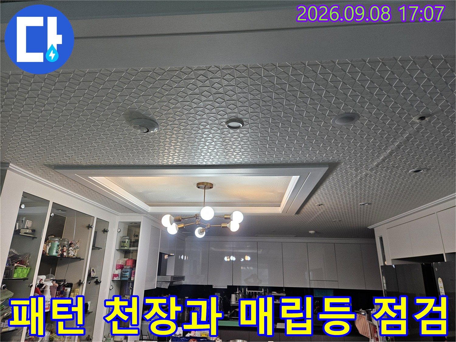 기하학적 패턴의 천장 마감재와 중앙 조명 시설물 모습