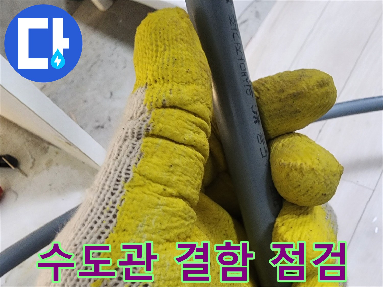 노란-작업용-장갑을-낀-손이-회색-배관을-잡고-있음